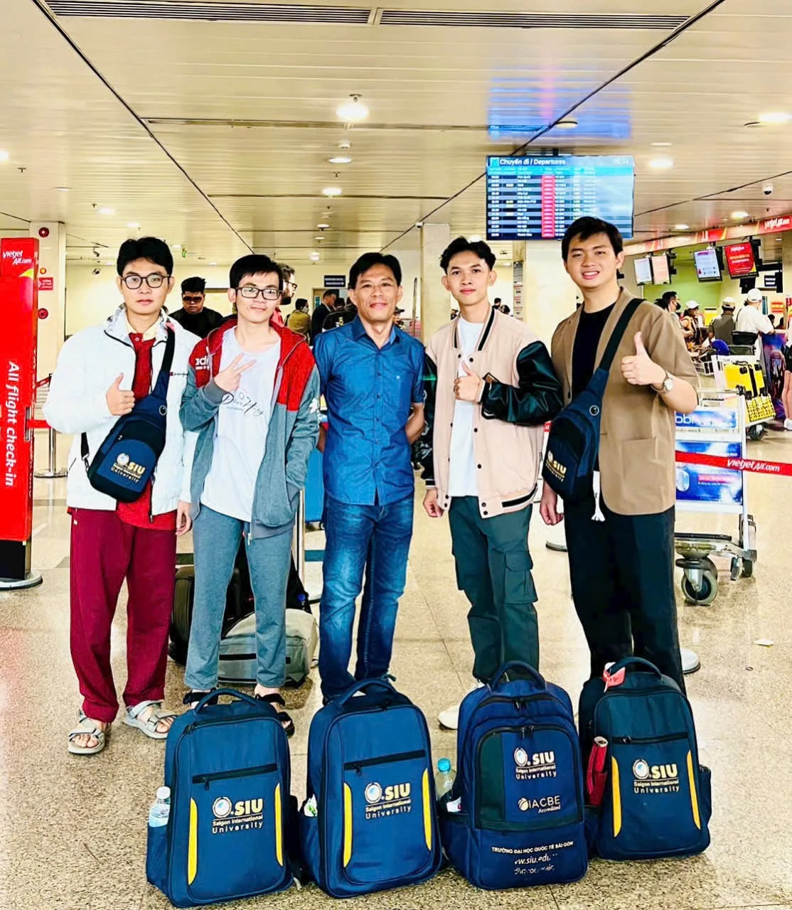Nhóm bạn cùng hành lý và ba lô SIU tại sảnh nhà ga.