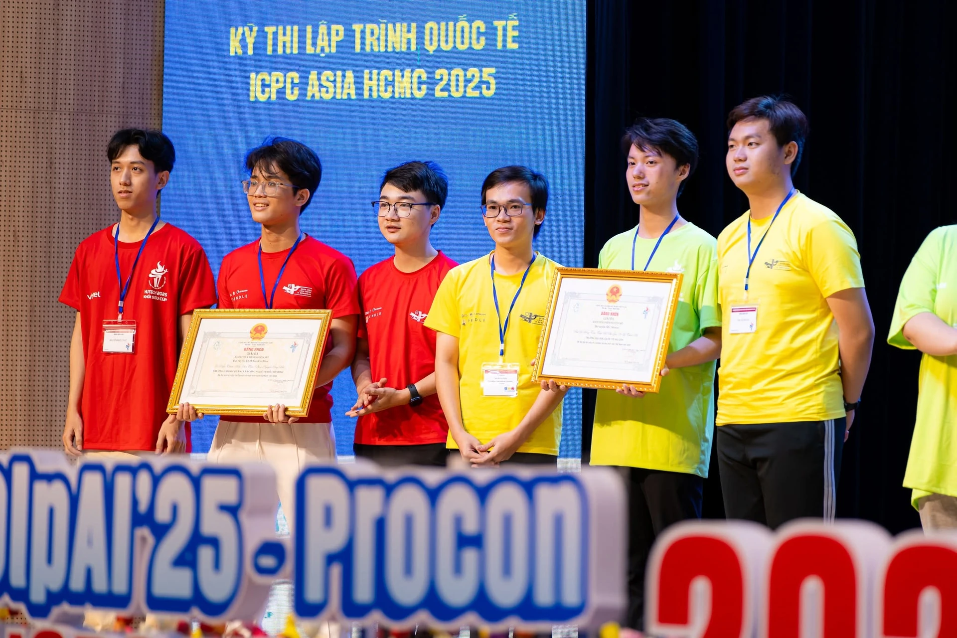 Các thành viên cùng bằng khen trên sân khấu OLP và ICPC Asia HCMC 2025.
