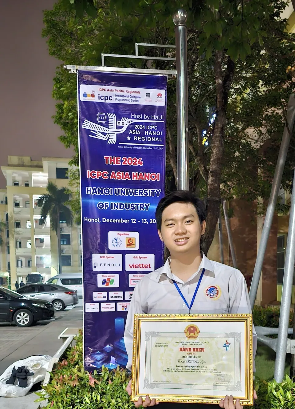 A commemorative photo with a Third Prize certificate in the specialized division beside the ICPC Asia Hanoi 2024 backdrop.