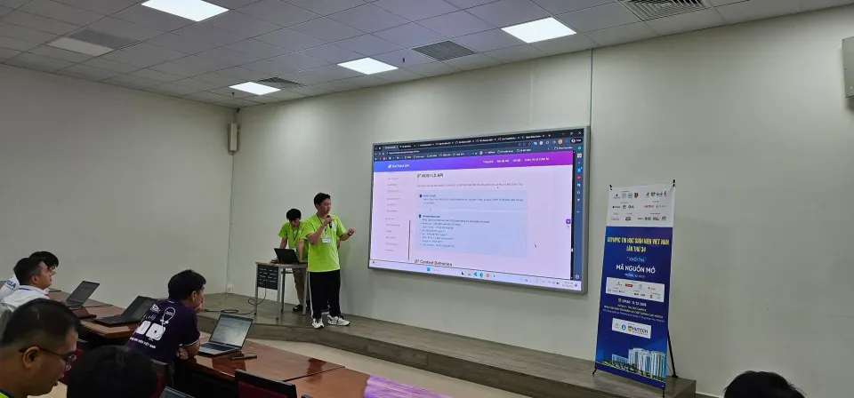 Team members presenting in front of a projection screen in the Open Source Software competition room.